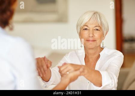 Jeder braucht ab und zu ein wenig Unterstützung. Porträt einer älteren Frau, die ihre Töchter in der Hand hält. Stockfoto