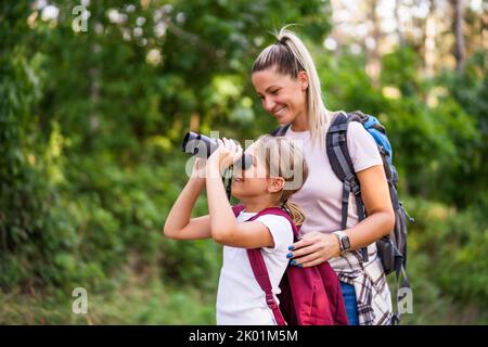 Mutter und Tochter benutzen Ferngläser und wandern gerne zusammen. Stockfoto