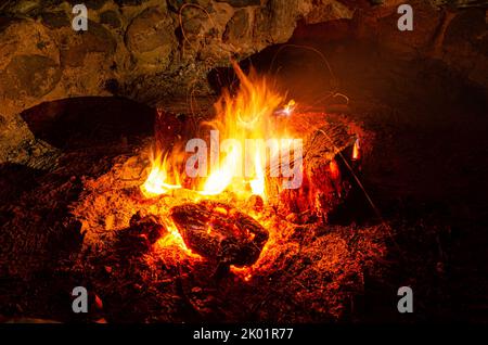 Brennende Holzstämme in einem Lagerfeuer in einer Feuerstelle. Stockfoto
