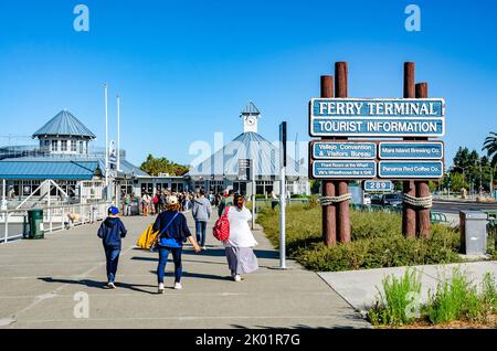 Besucher kommen am Vallejo Ferry Terminal in Kalifornien, USA, an den Touristeninformationsschildern vorbei, die vor blauem Himmel stehen Stockfoto