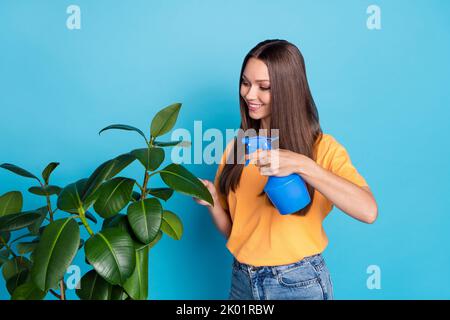 Porträt der fröhlichen vorsichtig Mädchen Bewässerung Blume Baumschule Hydratation häusliche Verfahren leeren Raum auf blauem Hintergrund isoliert Stockfoto