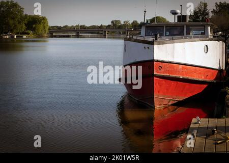 Die Sonne wärmt die Seite eines Fischtrawlers, der im Fluss an zwei Flüssen, Wisconsin, festgemacht ist. Stockfoto