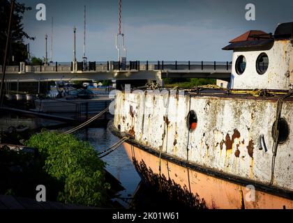 Die Sonne wärmt den Bug eines alten Fischtrawlers, der im Fluss bei Two River, Wisconsin, festgemacht ist. Stockfoto