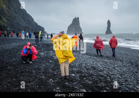 Touristen, die Fotos am Black Sand Beach (Reynisfjara), Vik, Island, machen Stockfoto