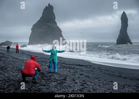 Touristen, die Fotos am Black Sand Beach (Reynisfjara), Vik, Island, machen Stockfoto