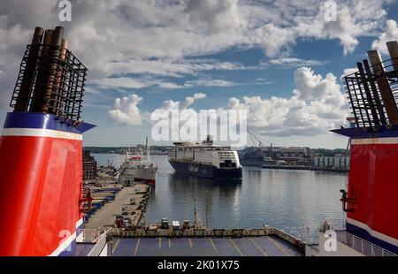 Kiel, Deutschland. 08. August 2022. Die Fähre 'Magic' von Color Line Cruises kommt rückwärts im Kieler Hafen an. Auf der linken Seite des Sartorikai befindet sich das Cap San Diego, das größte Museumsfrachtschiff der Welt. Im Vordergrund sind die roten Trichter einer Stena Line Fähre zu sehen. Quelle: Soeren Stache/dpa/Alamy Live News Stockfoto