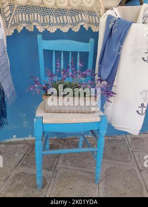 Eine vertikale Aufnahme von englischen Lavendel im Topf auf dem blauen Stuhl Stockfoto