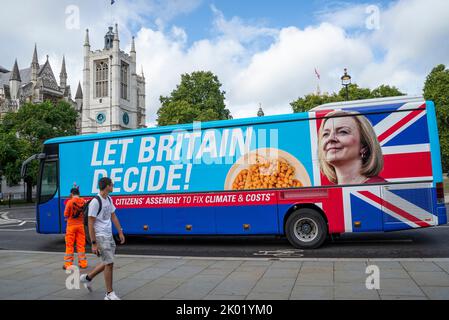 Ein Schwindel-Bus von Extinction Rebellion mit dem Aussehen eines Liz Truss-Kampagnenbusses. Bürgerversammlung und lasst Großbritannien über Slogans entscheiden. Im Parlament Stockfoto