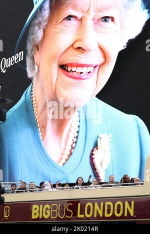 London, Großbritannien. 8. September 2022. Touristen in einem Sightseeing-Bus fahren am Tag nach dem Tod des britischen Monarchen am Piccadilly Circus im Zentrum von London an einem riesigen Bild von Queen Elizabeth II vorbei. Quelle: James Boardman/Alamy Live News Stockfoto