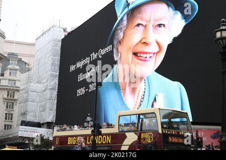 London, Großbritannien. 8. September 2022. Touristen in einem Sightseeing-Bus fahren am Tag nach dem Tod des britischen Monarchen am Piccadilly Circus im Zentrum von London an einem riesigen Bild von Queen Elizabeth II vorbei. Quelle: James Boardman/Alamy Live News Stockfoto