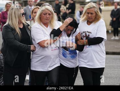 Margaret Cash McDonagh (zweite rechts), die Mutter von Lisa Cash, 18, und ihren achtjährigen Zwillingsgeschwistern Christy und Chelsea Cawley, wird nach ihrem Trauerdienst in der St. Aidan's Church, Brookfield, Tallaght, getröstet. Bilddatum: Freitag, 9. September 2022. Stockfoto