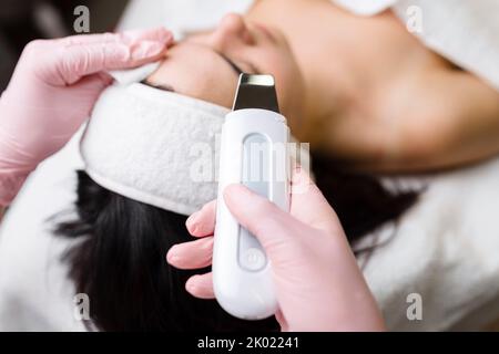 Gesichtsreinigung mit Ultraschall-Scrubber. Frau erhält Ultraschall-Gesichtspeeling und -Reinigung. Kosmetik- und Gesichtspflege. Gesichtsbehandlung Stockfoto