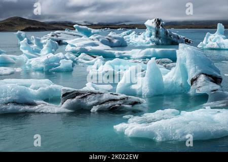 Eisberge, die vom Breidamerkurjokull-Gletscher in der Jokulsarlon-Gletscherlagune, Island, zum Meer hin abgebrochen sind Stockfoto