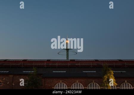 Kopenhagen, Dänemark. 13. August 2022. Langzeitaufnahme der Star Flyer-Vergnügungsfahrt in den Tivoli-Gärten, die sich gegen den späten Abendhimmel dreht Stockfoto