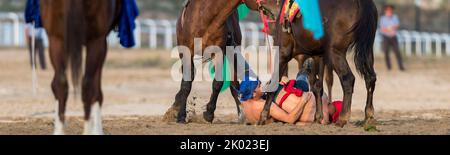 Zwei Ringer fielen während eines Er Enish bei den World Nomad Games 2018 in Kirgisistan auf den Boden. Stockfoto