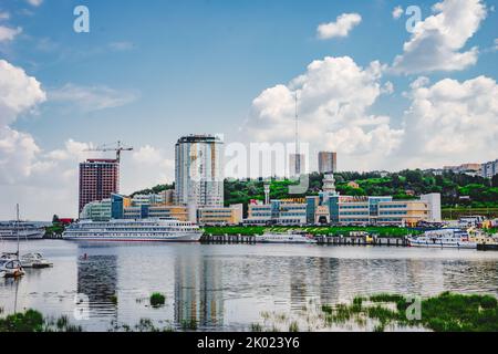 Tscheboksary, Russland. 2022, Juli 25. Flusshafen und neue Häuser am Ufer der Wolga. Stadtbild von Cheboksary Stockfoto