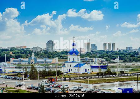 Tscheboksary, Russland. 2022, Juli 25. Kirche der Himmelfahrt der Heiligen Jungfrau am Flussufer. Stadtbild von Cheboksary Stockfoto