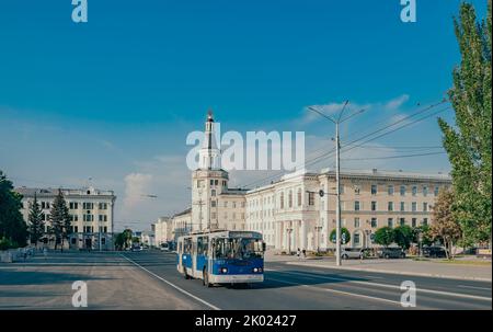 Tscheboksary, Russland. 2022, Juli 25. Platz der Republik im Zentrum der Stadt. Das Gebäude der staatlichen Agraruniversität Tschuwasch. Der alte blaue Trolleybus. Stockfoto