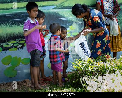 Mutter füttert arme Kinder einige erhielten Schokolade in Sri Lanka 30.. Juli 2022 Stockfoto