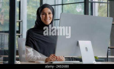 Selbstbewusst erfolgreiche elegante arabische Geschäftsfrau Eingabe auf Computer Attraktive muslimische Frau in Hijab professionelle Arbeiter erfahrene Manager Stockfoto
