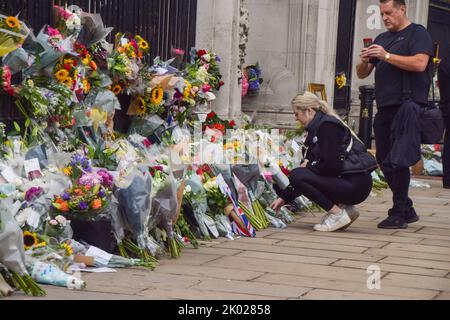 London, Großbritannien. 9. September 2022. Eine Frau hinterlässt Blumen vor dem Buckingham Palace, als Königin Elizabeth II. Im Alter von 96 Jahren stirbt. Kredit: Vuk Valcic/Alamy Live Nachrichten Stockfoto