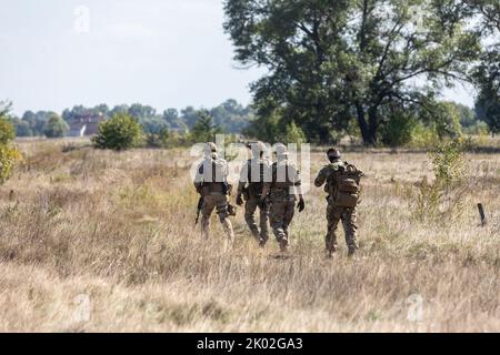 KIEW REG., UKRAINE - 08. September 2022: Eine Gruppe von Militäranhängern wird während eines Tests eines Evakuierungsroboters, der für Evakuierungszwecke an der Front eingesetzt wird, auf dem Feld gesehen Stockfoto