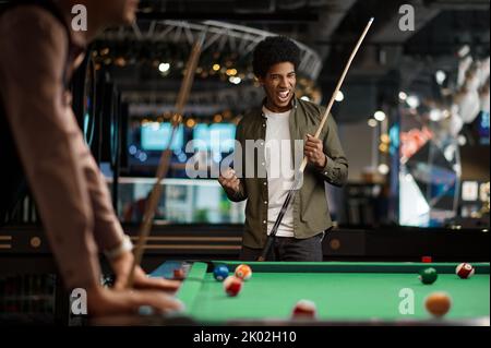 Junger Poolspieler freut sich über erfolgreichen Treffer Stockfoto