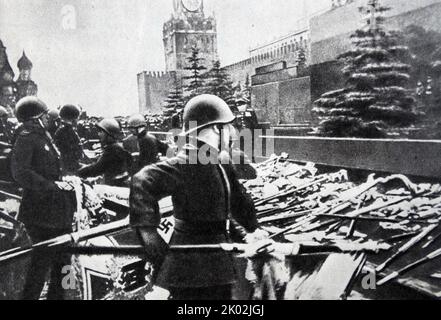 Bei der Moskauer Siegesparade von 1945, die die Niederlage Nazi-Deutschlands markierte, gab es insgesamt 201 deutsche Militärstandards und -Farben, die Mehrheit stammte aus der Wehrmacht. Getragen von einem Bataillon sowjetischer Soldaten aus der separaten Einsatzabteilung des NKWD wurden sie während des vormarsches an der Bodensäule unter Trommelwirbel auf die Stufen des Leninschen Mausoleums geworfen. Stockfoto