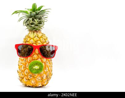 Ananas isoliert auf weißem Hintergrund mit dem Konzept des Sommers, trägt Brille und Kiwi als Mund Stockfoto