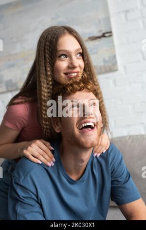 Glücklich teen Mädchen lächelnd und umarmt aufgeregt Freund im Wohnzimmer, Stock Bild Stockfoto