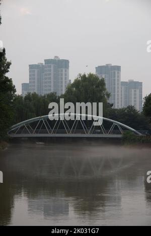 Eine vertikale Aufnahme einer modernen Brücke über ein klares Flusswasser im Qinglonghu Park, Bezirk Longquanyi, Stadt Chengdu, Provinz Sichuan, China Stockfoto