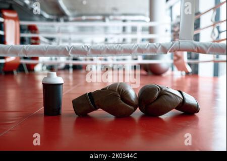 Boxhandschuhe und Wasserflasche am Ring Stockfoto
