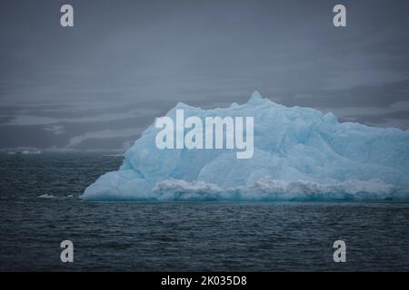 Vor der Küste bei Spitzbergen driftet ein Eisberg. Stockfoto