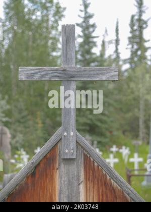 Altes Holz. Kreuz Nahaufnahme mit unfokussierten Feld von weißen Kreuzen von graveyard.in Dawson City. Stockfoto