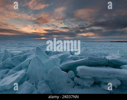 Die Sonne untergeht über den Gewässern der Green Bay (Lake Michigan) vom Ufer des Peninsula State Park mit Eisschiefen im Vordergrund, Door County, Wisconsin Stockfoto