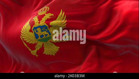Nahaufnahme der im Wind winkenden Nationalflagge Montenegros. Montenegro ist ein Land in Südosteuropa. Texturierter Hintergrund aus Stoff. Selektiv Stockfoto