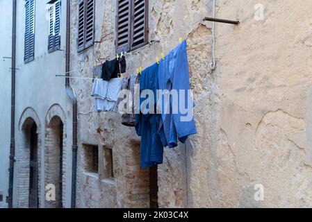 Wäsche zum Trocknen an einer Hauswand, Castiglione della Pescaia, Provinz Grosseto, Toskana, Italien. Stockfoto
