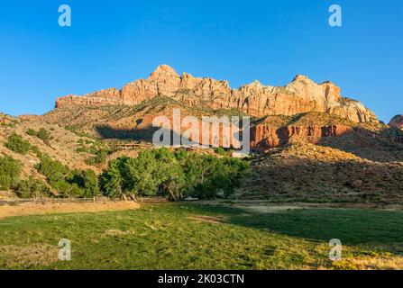 Der Zion National Park liegt im Südwesten von Utah an der Grenze zu Arizona. Es hat eine Fläche von 579 kö² und liegt zwischen 1128 m und 2660 m Höhe. Die Berggipfel des Berges Kinesava auf der linken Seite und der westliche Tempel auf der rechten Seite. Stockfoto