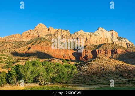 Der Zion National Park liegt im Südwesten von Utah an der Grenze zu Arizona. Es hat eine Fläche von 579 kö² und liegt zwischen 1128 m und 2660 m Höhe. Die Berggipfel des Berges Kinesava auf der linken Seite und der westliche Tempel auf der rechten Seite. Stockfoto