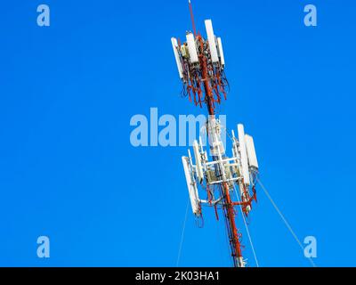 Der rot-weiße 5G-Turm mit blauer Himmelshintergrundstrahlung tötet uns in Playa del Carmen in Mexiko. Stockfoto