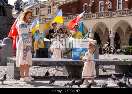 Krakau, Polen. 09. September 2022. Mädchen in ukrainischen Volkskleidern spielen, während Ukrainer und ihre Anhänger am 9. September 2022 auf dem Hauptplatz in der Altstadt von Krakau, Polen, gegen einen über sechs Monate alten russischen Krieg gegen die Ukraine protestieren. Die Demonstranten kommen zweimal täglich auf die Straßen von Krakau, um, wie sie sagen, an das Schicksal der ukrainischen Bevölkerung zu erinnern. (Foto von Dominika Zarzycka/Sipa USA) Quelle: SIPA USA/Alamy Live News Stockfoto