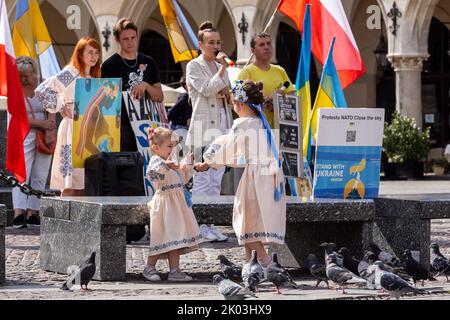 Krakau, Polen. 09. September 2022. Mädchen in ukrainischen Volkskleidern spielen, während Ukrainer und ihre Anhänger am 9. September 2022 auf dem Hauptplatz in der Altstadt von Krakau, Polen, gegen einen über sechs Monate alten russischen Krieg gegen die Ukraine protestieren. Die Demonstranten kommen zweimal täglich auf die Straßen von Krakau, um, wie sie sagen, an das Schicksal der ukrainischen Bevölkerung zu erinnern. (Foto von Dominika Zarzycka/Sipa USA) Quelle: SIPA USA/Alamy Live News Stockfoto