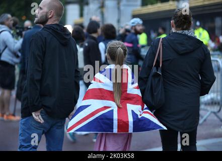 London, Großbritannien. 09. September 2022. Ein junges Mädchen trägt als Umhang eine Gewerkschaftsflagge, als sie und ihre Eltern der Königin vor den Toren des Buckingham Palace ihren Respekt zollen. Ihre Majestät Königin Elizabeth II. Ist im Alter von 96 Jahren in Balmoral Castle gestorben, nachdem sie 70 Jahre lang über das Vereinigte Königreich regiert hat. Kredit: SOPA Images Limited/Alamy Live Nachrichten Stockfoto