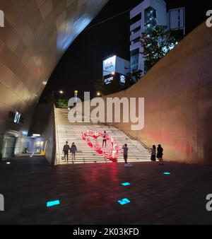 Das Dongdaemun Design Plaza, abgekürzt DDP, ist ein bedeutendes städtebauliches Wahrzeichen in Seoul, Südkorea, entworfen von Zaha Hadid und Samoo, mit einem unverwechselbaren neo-futuristischen Design, das sich durch die „kraftvollen, geschwungenen Formen länglicher Strukturen“ auszeichnet. Das Wahrzeichen ist das Herzstück von Südkoreas Modezentrum und beliebtes Touristenziel, Dongdaemun, mit einem begehbaren Park auf seinen Dächern, großen globalen Ausstellungsräumen, futuristischen Einzelhandelsgeschäften und restaurierten Teilen der Festung Seoul. Die DDP war einer der Hauptgründe für die Ernennung Seouls zur World Design Capital im Jahr 2010. Stockfoto