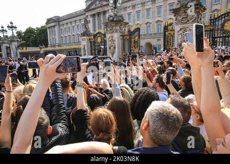 London, Großbritannien. 09. September 2022. Die Leute halten ihre Handys hoch, um einen Blick auf König Charles zu werfen, der zu den Ehrungen geht. Nach dem Tod von Königin Elizabeth II. Legen viele Trauernde, aber auch viele Touristen Blumen nieder und zollen ihren Tribut an den Toren des Buckingham Palace, und die Gegend wird sehr voll mit Menschen. Kredit: Imageplotter/Alamy Live Nachrichten Stockfoto