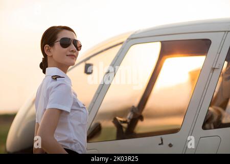 Chinesischer Hubschrauberpilot, der neben dem Fahrzeug steht Stockfoto