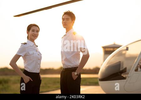 Chinesische Hubschrauberpiloten stehen neben dem Fahrzeug Stockfoto