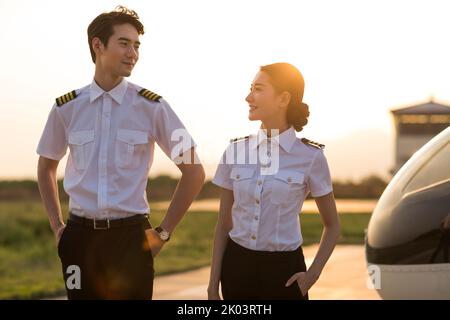 Chinesische Hubschrauberpiloten stehen neben dem Fahrzeug Stockfoto
