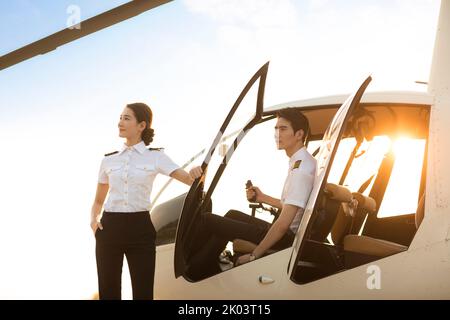 Chinesischer Hubschrauberpilot, der neben dem Fahrzeug steht Stockfoto