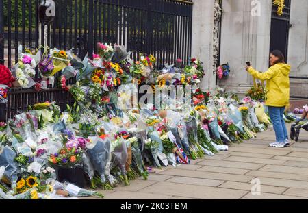 London, Großbritannien. 9. September 2022. Eine Frau hinterlässt Blumen vor dem Buckingham Palace, als Königin Elizabeth II. Im Alter von 96 Jahren stirbt. Kredit: Vuk Valcic/Alamy Live Nachrichten Stockfoto